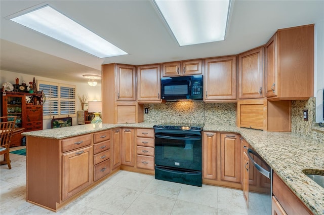 kitchen featuring decorative backsplash, light stone countertops, kitchen peninsula, and black appliances