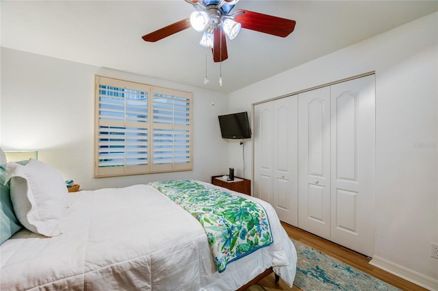 bedroom featuring wood-type flooring, ceiling fan, and a closet