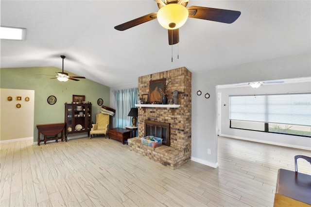 living room featuring hardwood / wood-style flooring, ceiling fan, vaulted ceiling, and a brick fireplace