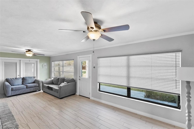 living room with crown molding, ceiling fan, and light wood-type flooring