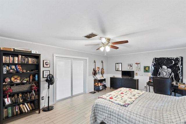 bedroom featuring crown molding, light hardwood / wood-style flooring, and ceiling fan