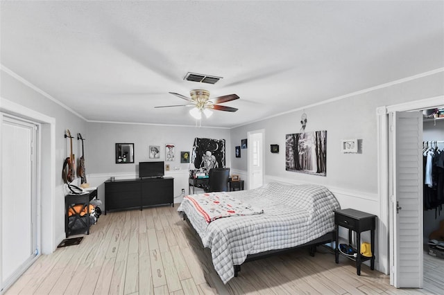 bedroom featuring hardwood / wood-style flooring, ornamental molding, a closet, and ceiling fan