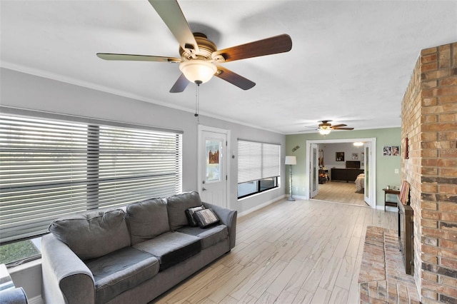 living room featuring ornamental molding, a brick fireplace, and light wood-type flooring