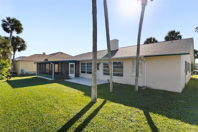 back of property featuring a yard, a patio, and a sunroom