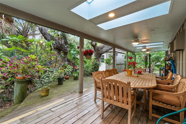 sunroom featuring ceiling fan, a skylight, and a wealth of natural light