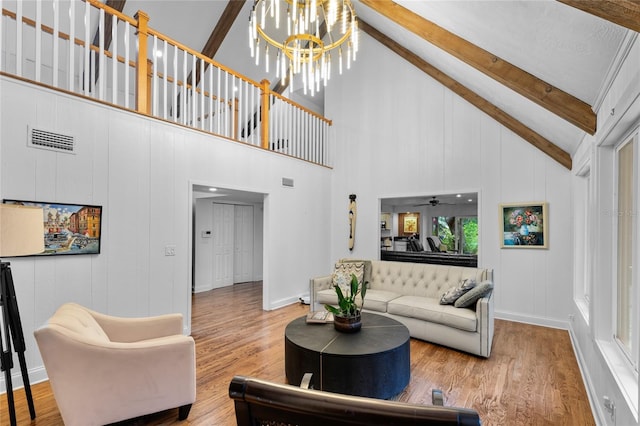 living room with vaulted ceiling with beams, wood-type flooring, and a notable chandelier