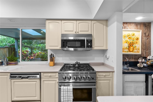 kitchen featuring cream cabinets, appliances with stainless steel finishes, and sink