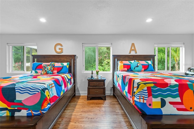 bedroom with hardwood / wood-style floors and a textured ceiling