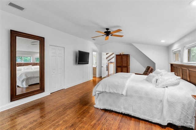 bedroom featuring hardwood / wood-style flooring, ceiling fan, ensuite bathroom, and multiple windows