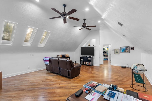 living room featuring lofted ceiling, hardwood / wood-style floors, and a textured ceiling