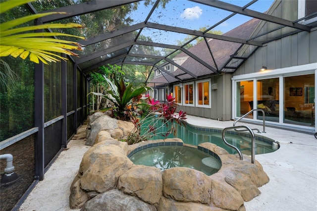 view of swimming pool with an in ground hot tub, a lanai, and a patio area