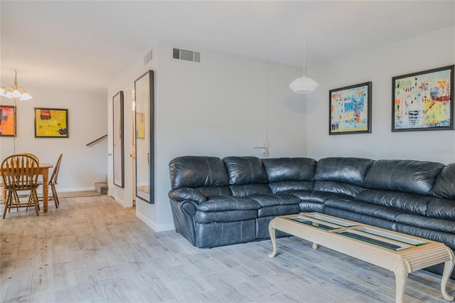 living room with light hardwood / wood-style floors and a chandelier