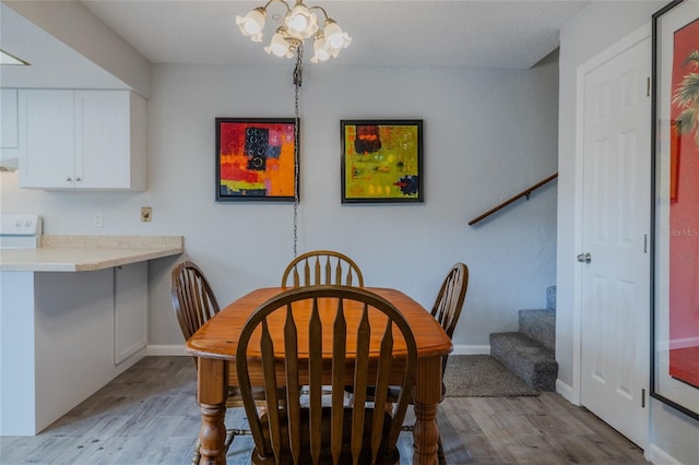 dining area featuring a notable chandelier and light wood-type flooring