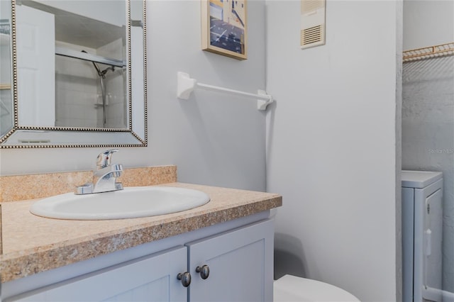 bathroom with vanity, washer / clothes dryer, toilet, and an enclosed shower