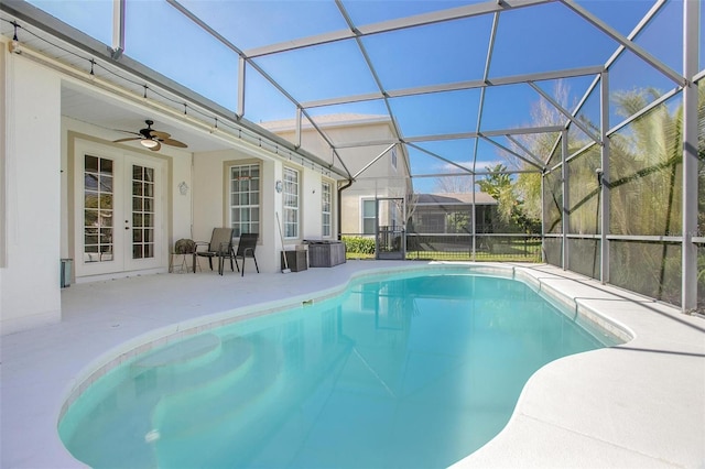 outdoor pool featuring a ceiling fan, a lanai, a patio area, and french doors