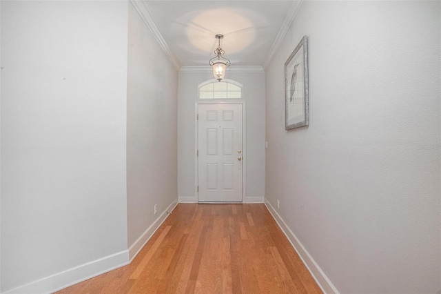 doorway to outside featuring crown molding, wood finished floors, and baseboards