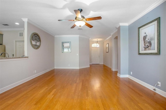 unfurnished living room featuring light wood-style floors, visible vents, and crown molding