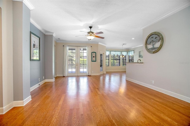 unfurnished living room with ornamental molding, french doors, light wood-style flooring, and baseboards