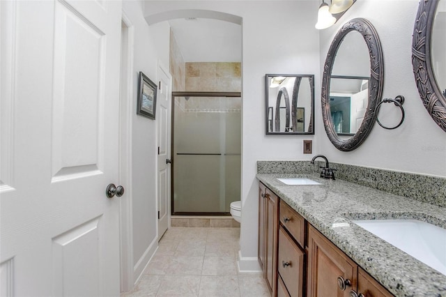 full bath with tile patterned flooring, a sink, a shower stall, and toilet