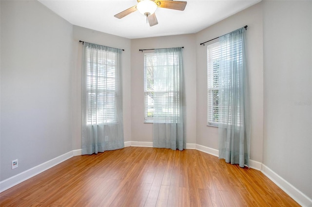 unfurnished room featuring light wood-style floors, ceiling fan, and baseboards