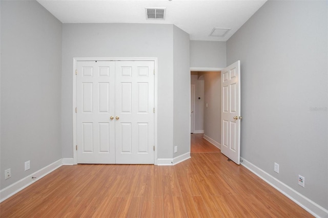 unfurnished bedroom with light wood-type flooring, a closet, visible vents, and baseboards