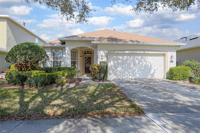 ranch-style home with a garage, a shingled roof, concrete driveway, stucco siding, and a front lawn