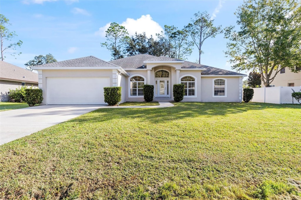 view of front of property with a garage and a front lawn