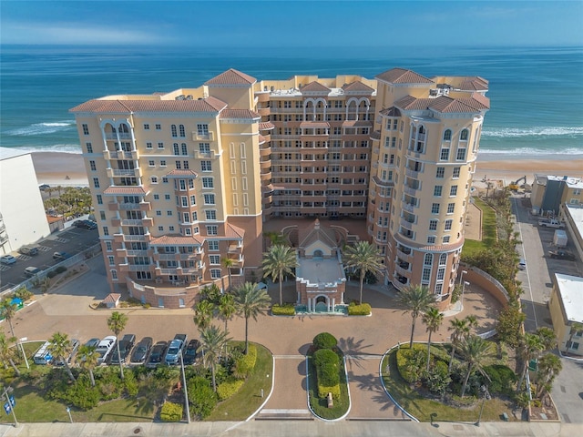 view of building exterior featuring a beach view and a water view