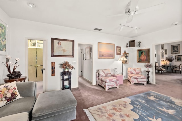 carpeted living room with ceiling fan and track lighting