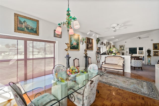 dining room featuring parquet flooring, rail lighting, ceiling fan, and vaulted ceiling