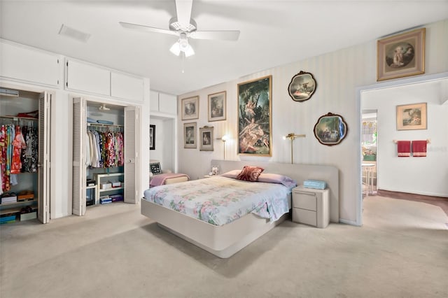 carpeted bedroom with two closets and ceiling fan