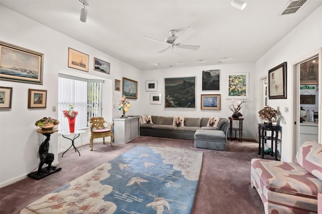 carpeted living room featuring track lighting and ceiling fan