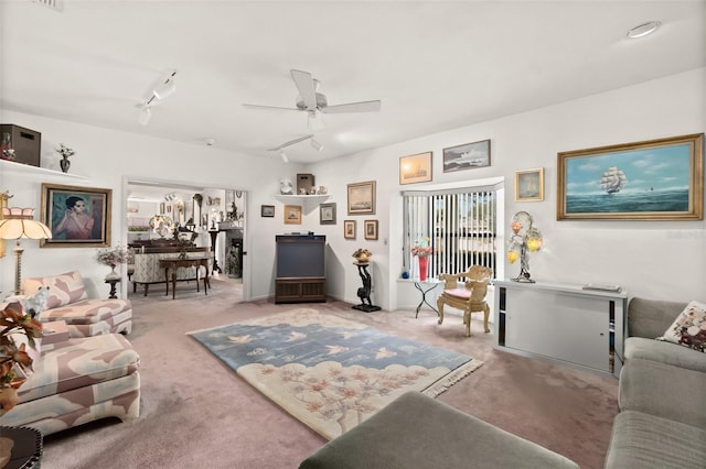 carpeted living room with track lighting and ceiling fan