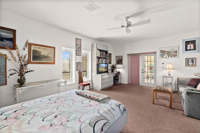 carpeted bedroom featuring multiple windows and ceiling fan