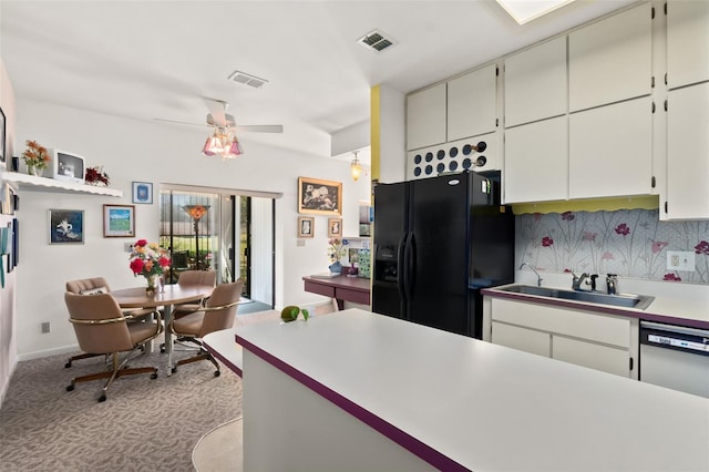 kitchen featuring sink, white cabinets, decorative backsplash, black fridge with ice dispenser, and light carpet