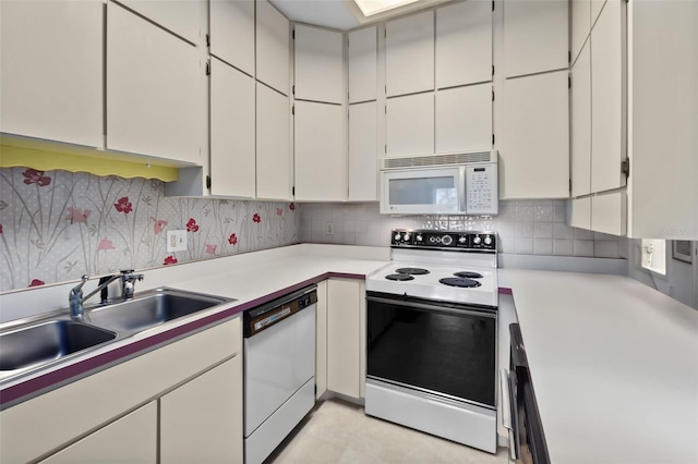 kitchen featuring white cabinetry, sink, white appliances, and tasteful backsplash