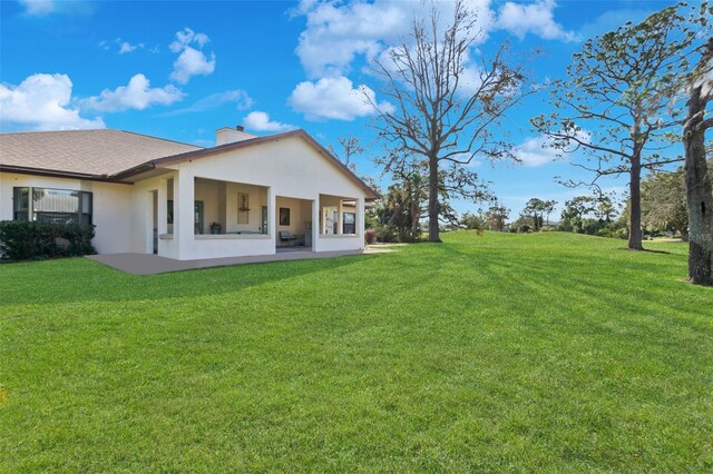 back of property featuring a yard and a patio area