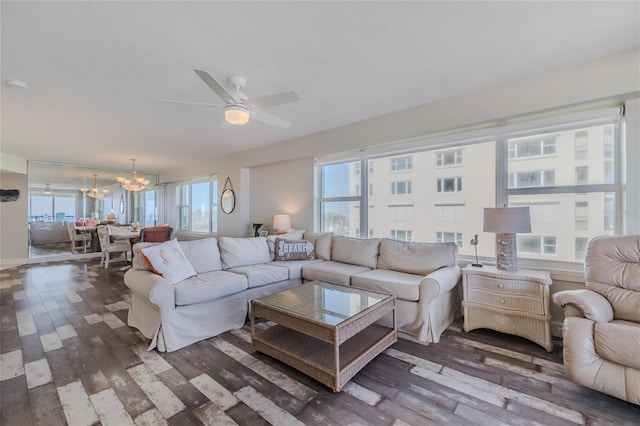 living room with hardwood / wood-style flooring and ceiling fan with notable chandelier