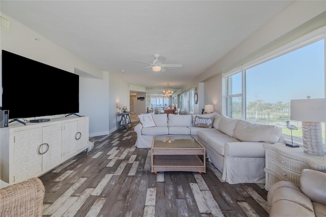 living room with dark hardwood / wood-style flooring and ceiling fan with notable chandelier