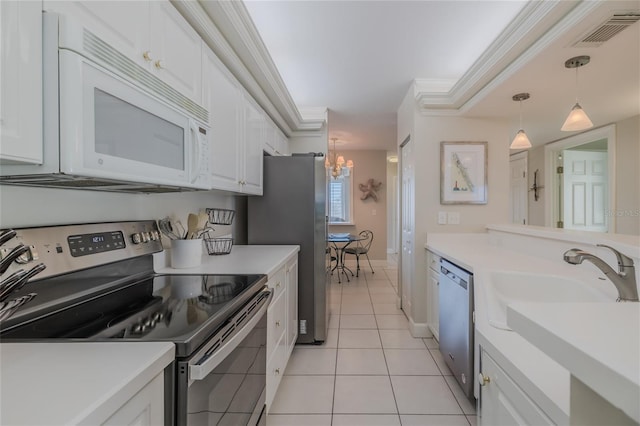 kitchen with light tile patterned flooring, white cabinetry, hanging light fixtures, stainless steel appliances, and crown molding