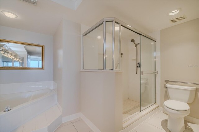 bathroom with tile patterned floors, toilet, and separate shower and tub