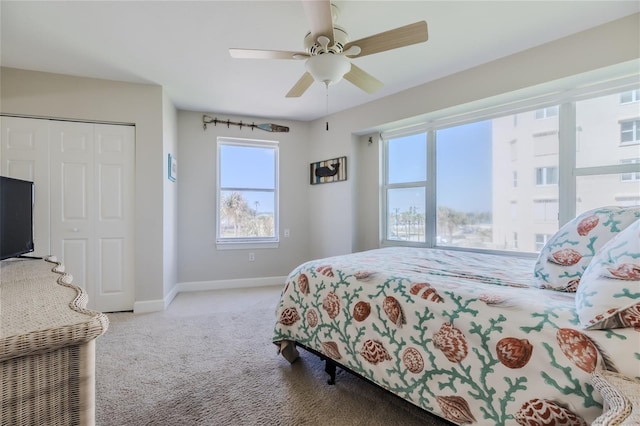 carpeted bedroom with ceiling fan and a closet