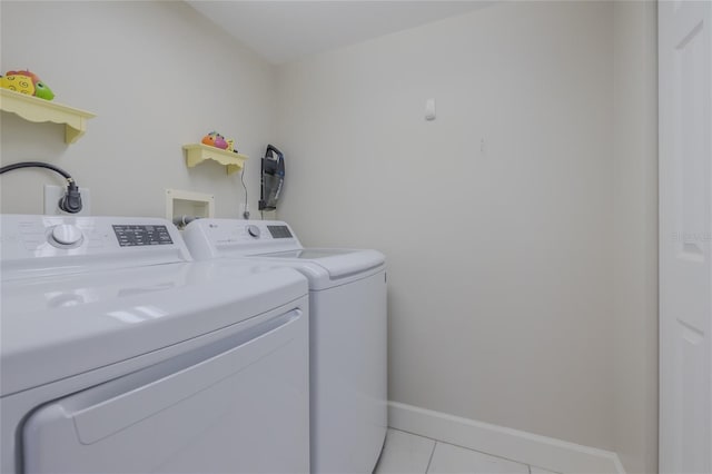 laundry room with washing machine and clothes dryer and light tile patterned floors