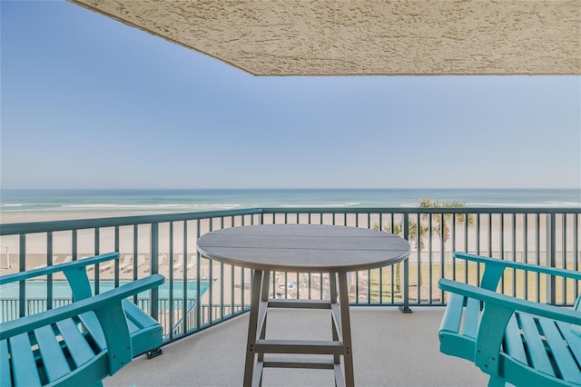 balcony with a water view and a beach view