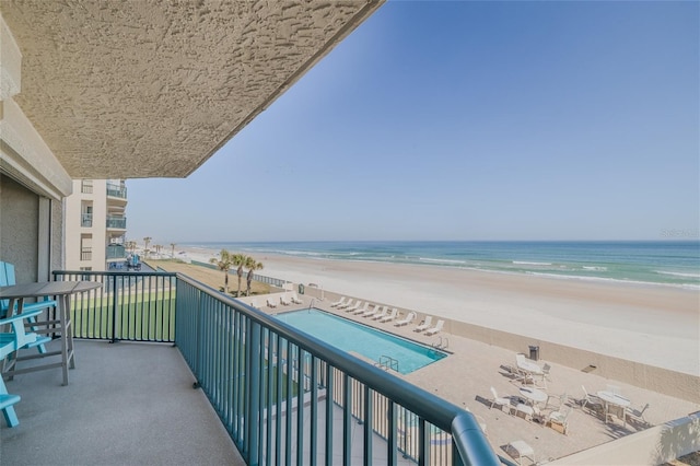 balcony featuring a view of the beach and a water view