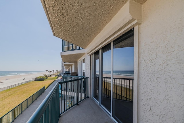 balcony featuring a water view and a view of the beach