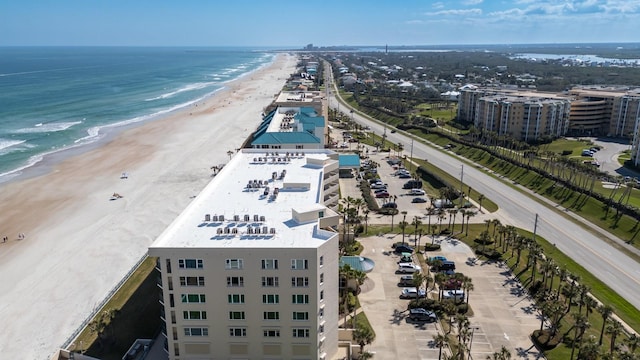 birds eye view of property featuring a water view and a beach view