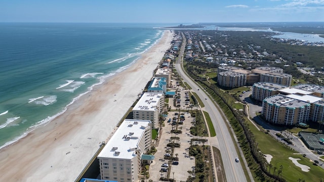 birds eye view of property with a water view and a beach view