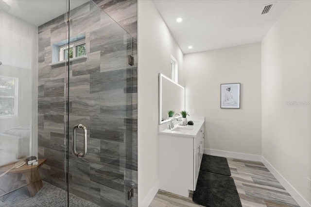 bathroom featuring hardwood / wood-style flooring, vanity, and an enclosed shower