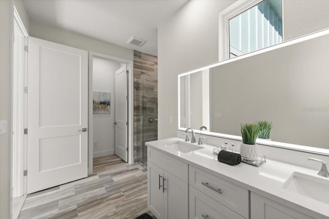 bathroom with a shower with door, vanity, and hardwood / wood-style flooring